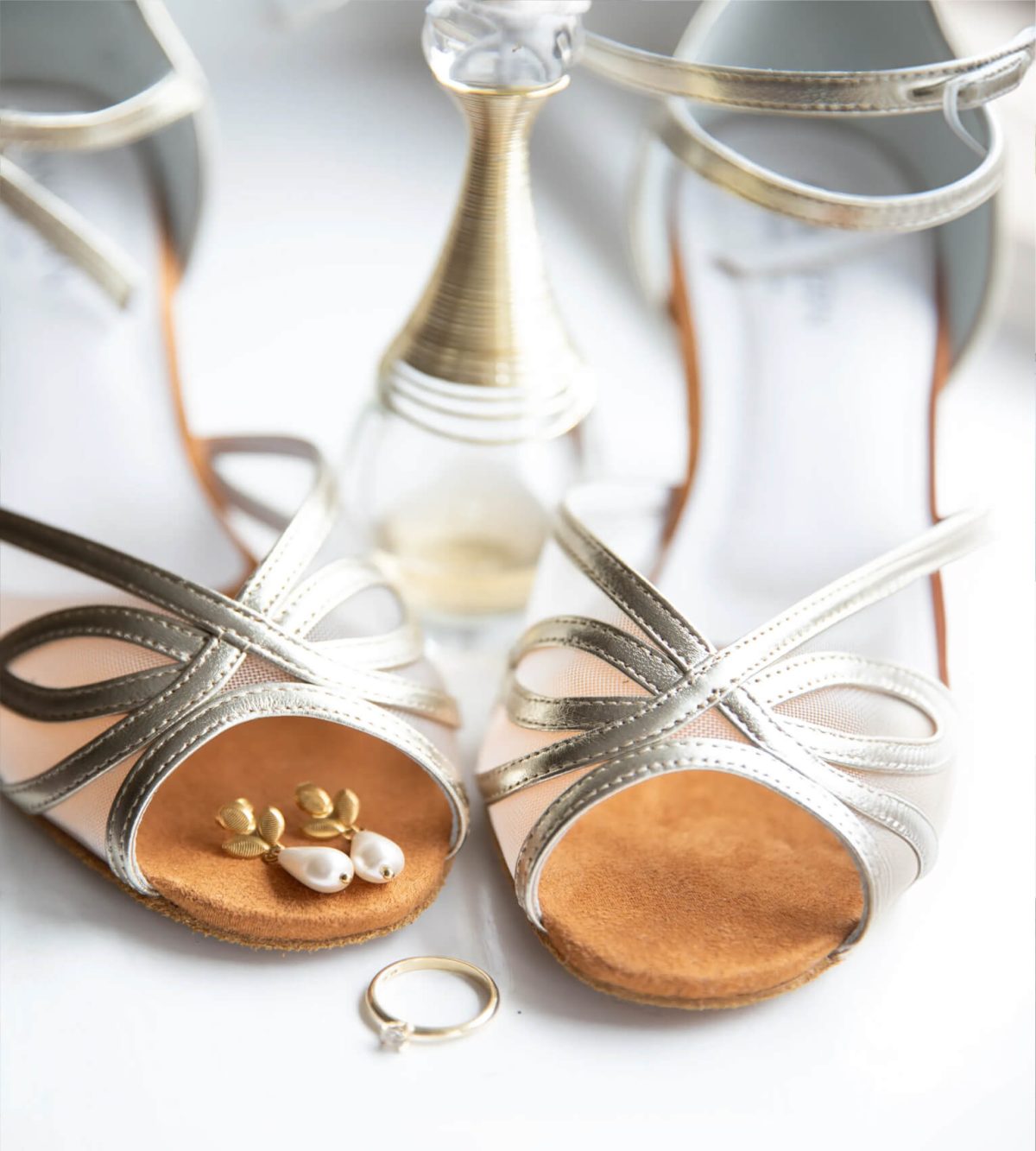 Detailfoto van trouwschoenen en trouwringen