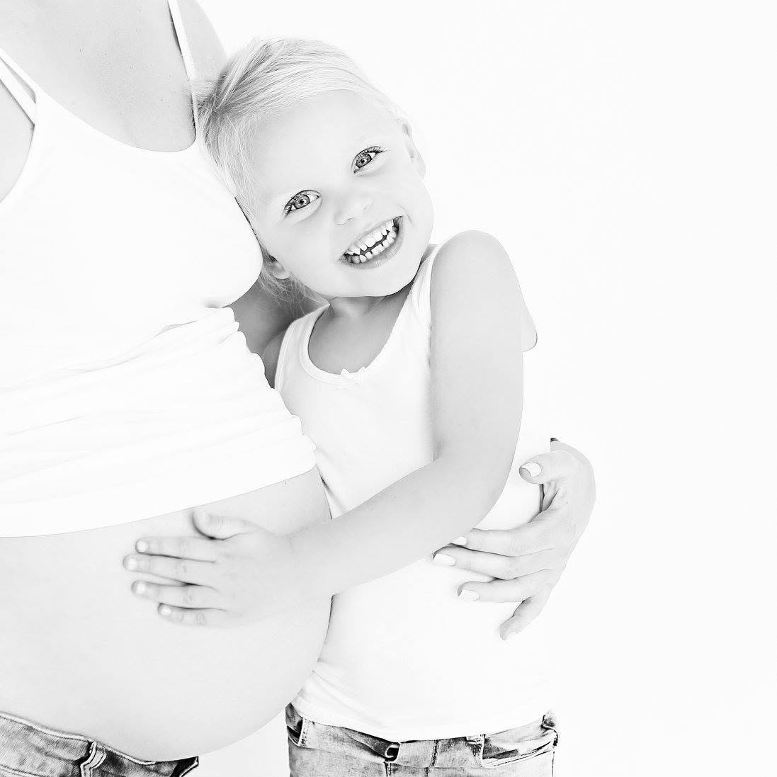Zwangere vrouw met haar kind tijdens een zwangerschapsshoot