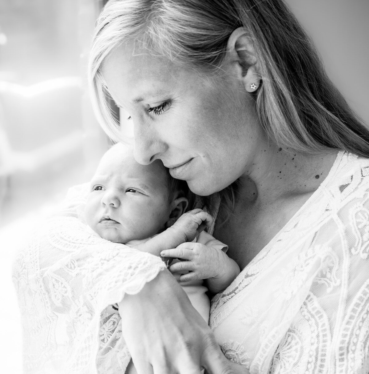 moeder met pasgeboren baby bij het raam