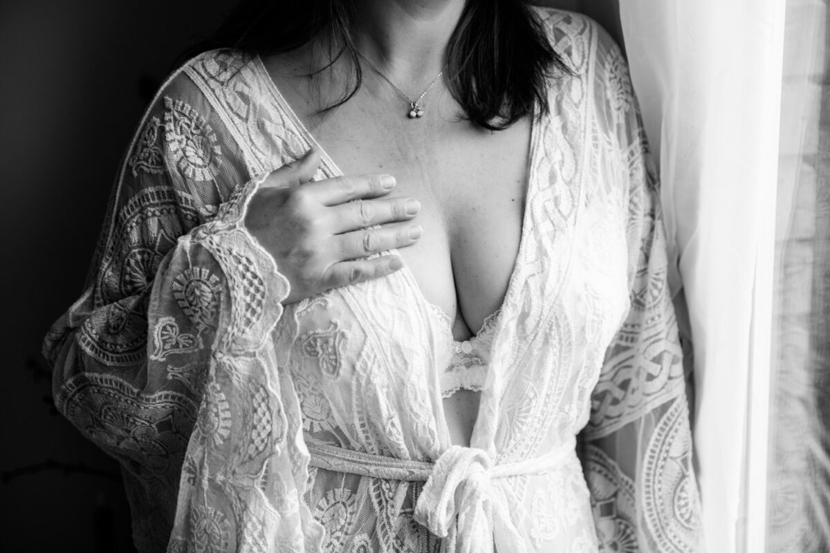 Vrouw in lingerie met kanten kimono tijdens een boudoirshoot