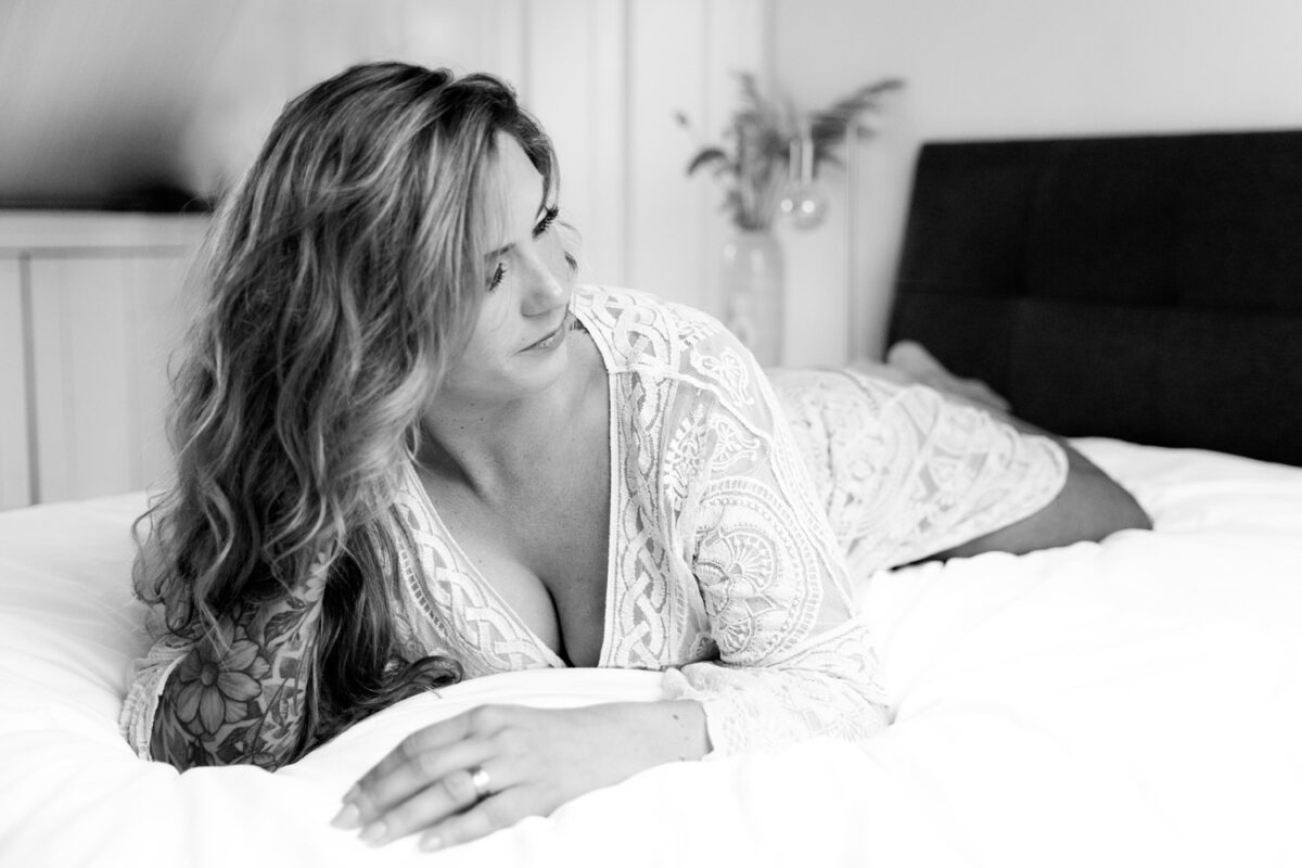 Vrouw in lingerie ontspannen op bed tijdens een boudoirshoot