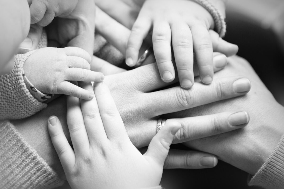 Handen van ouders rond de hand van hun baby