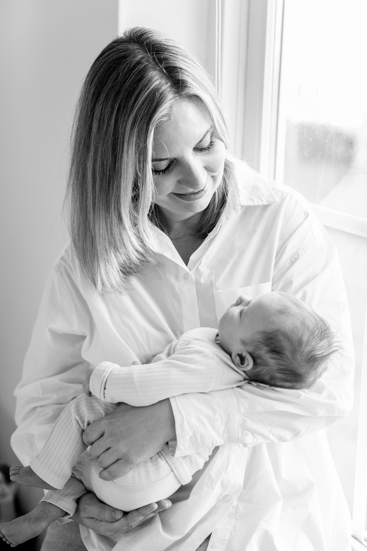 Moeder met pasgeboren baby bij het raam