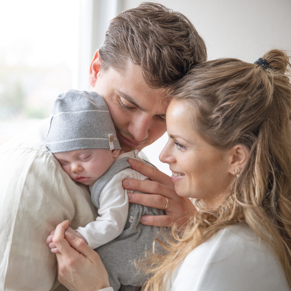 ouders met pasgeboren baby bij het raam
