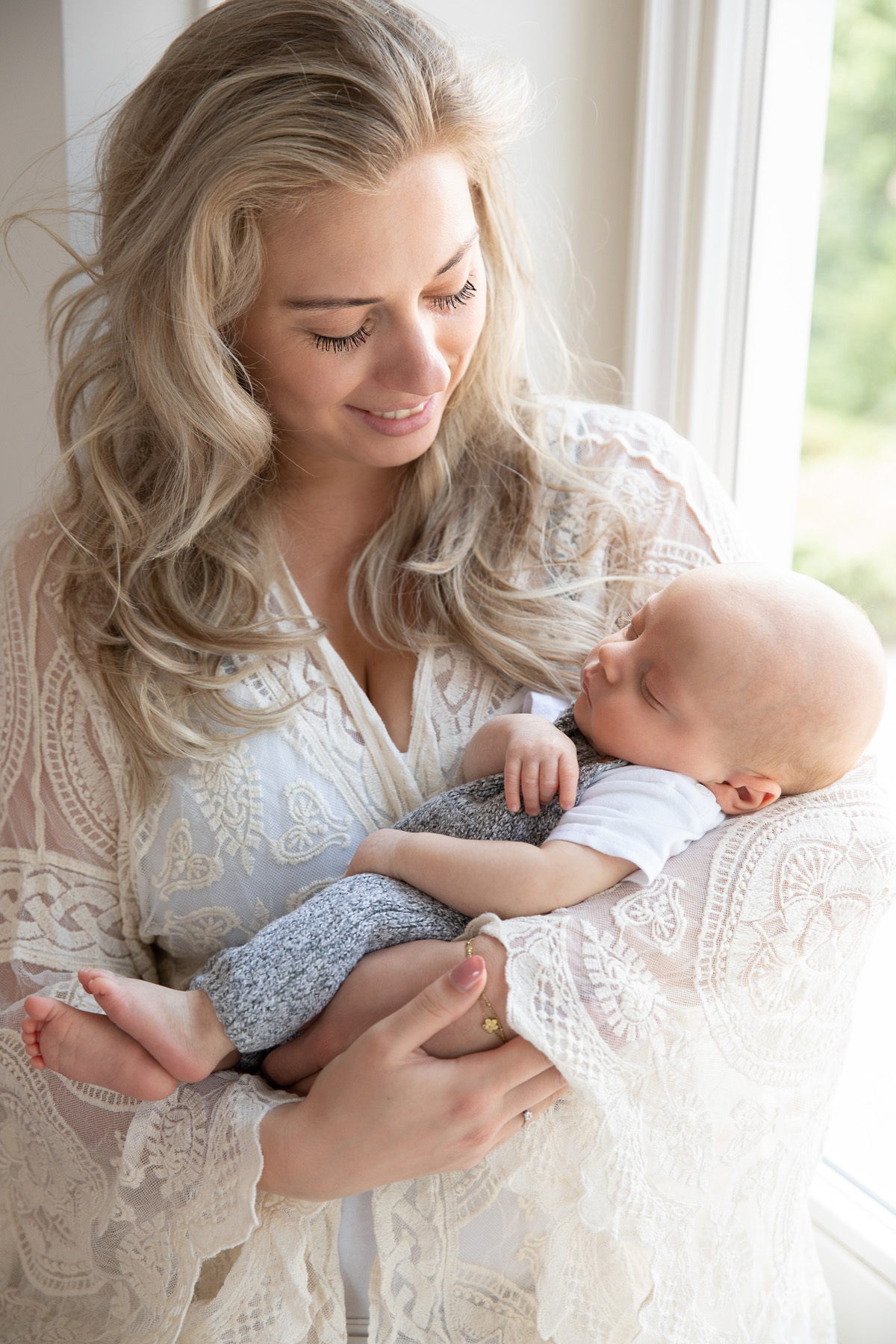 Moeder met haar baby in huis bij het raam