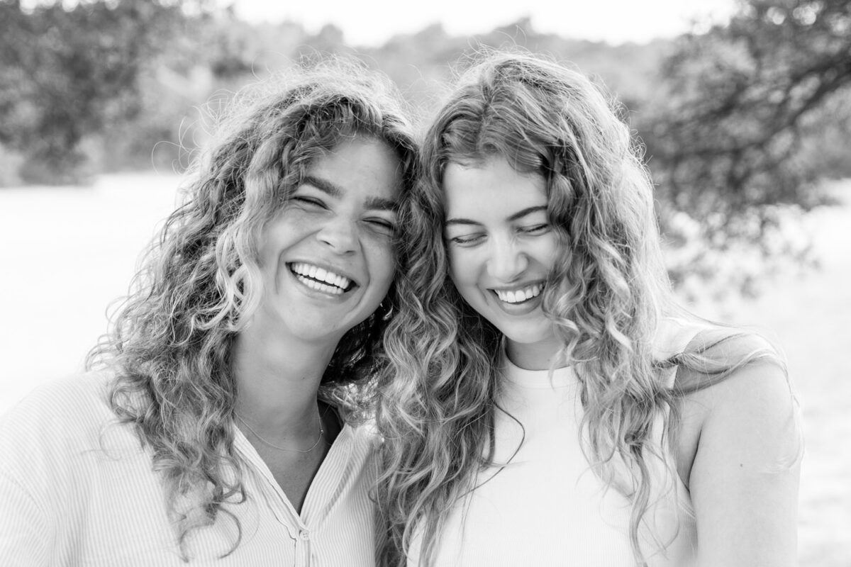 2 meiden met krullen die moeten lachen