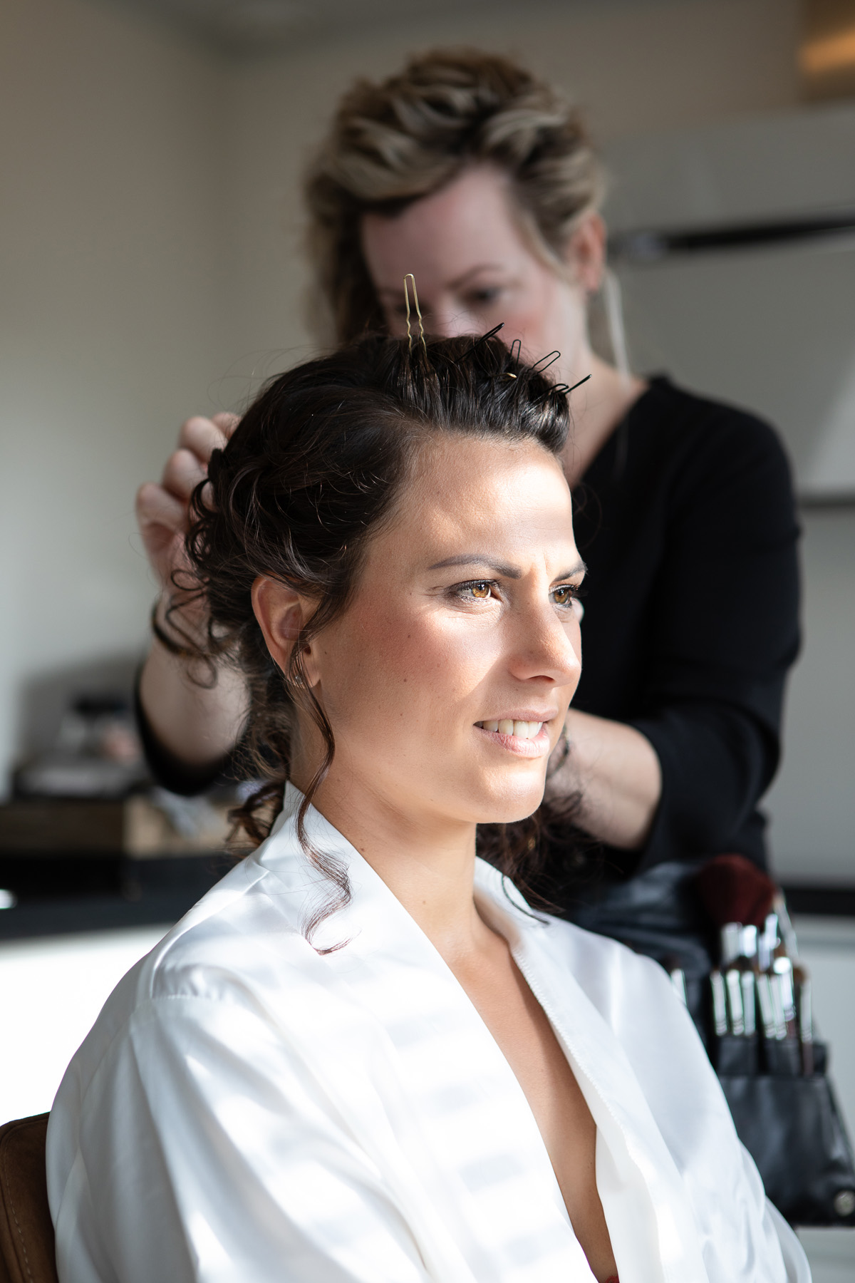 Bruid wordt professioneel opgemaakt voor haar trouwdag