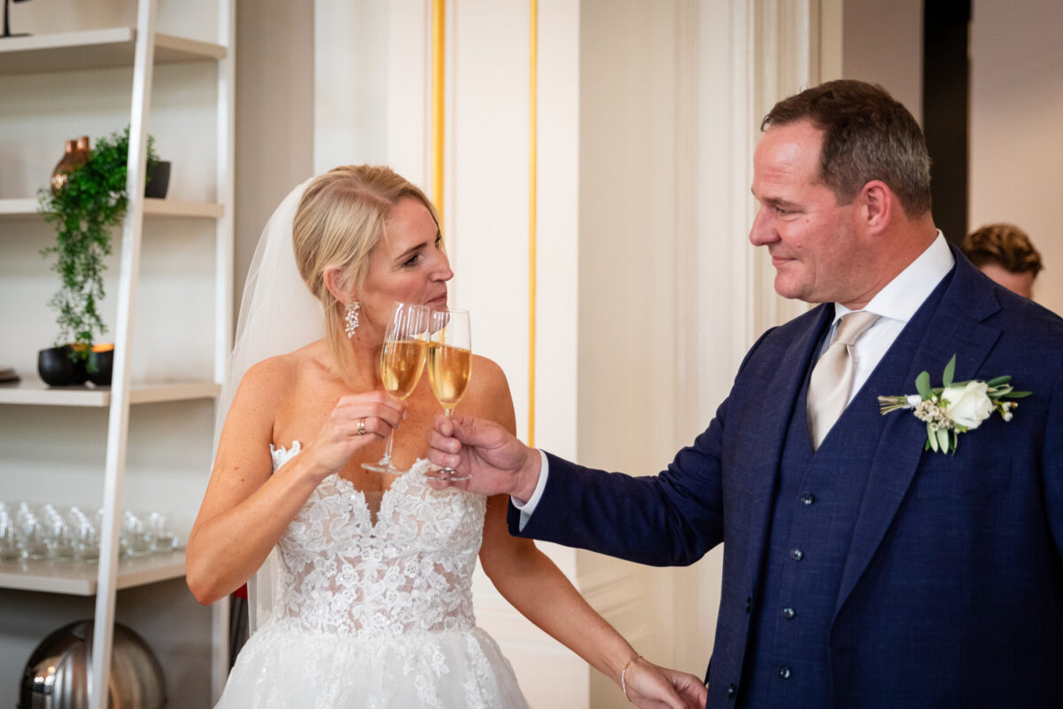 Bruidspaar proosten samen tijdens hun trouwdag