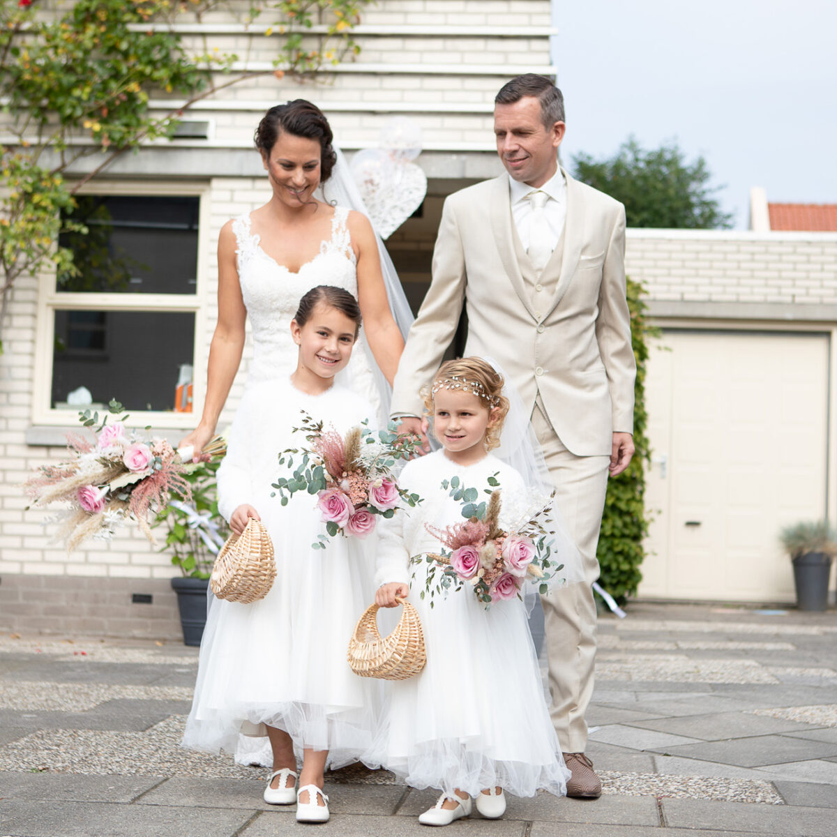 Bruid en bruidegom met hun kinderen bij de trouwlocatie