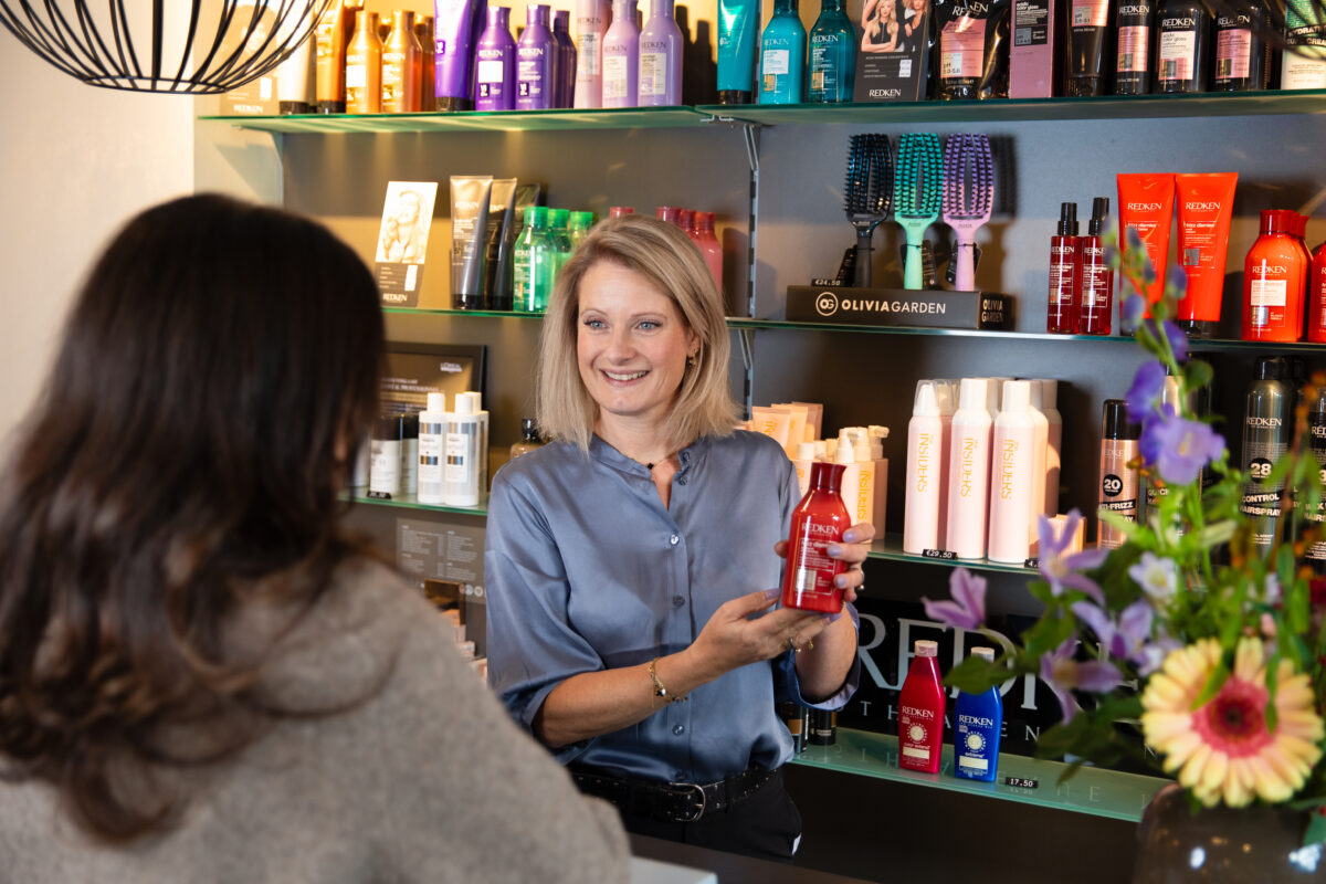 Medewerker van een kapsalon met een haarproduct