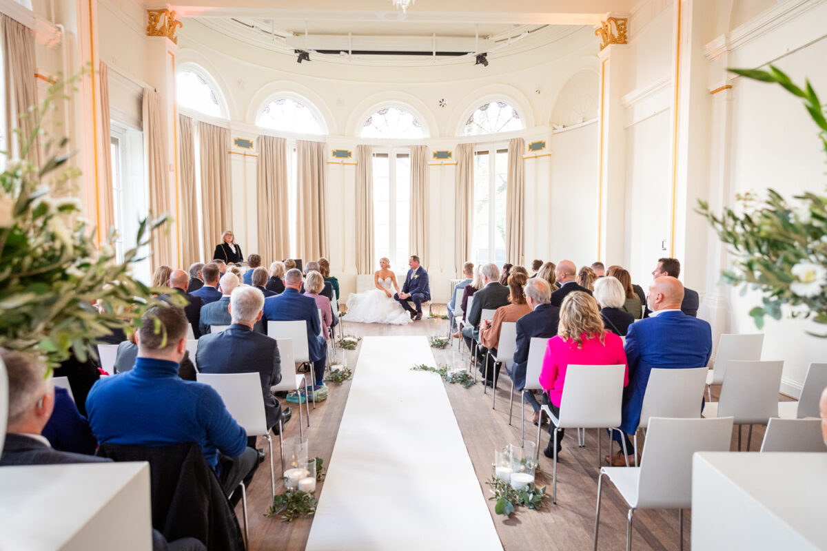 bruidspaar tijdens trouwceremonie en gasten